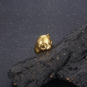 Macro shot of 3D embossed panda ring in retro gold finish on dark charcoal