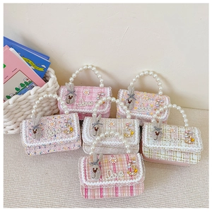 Detailed close-up of girls' tweed mini handbags with pearl handles and rabbit charms