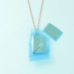 Close-up of envelope pendant with blue protective film and DIY insertable metal card
