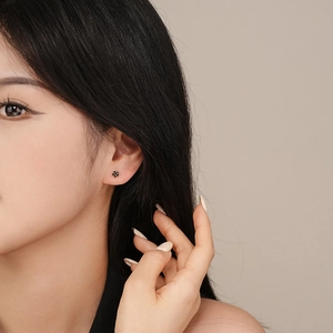 Minimalist s925 silver flower stud earrings with black petals and zircon on ear model