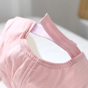 Detailed close-up of pink cotton baseball cap featuring adjustable Velcro closure system