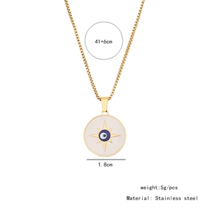 Macro detail of golden evil eye necklace featuring white enamel starburst pendant