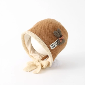 Detail of baby knit hat with warm ear flaps and decorative rabbit ears in caramel tone