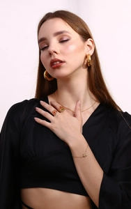 Close-up of gold-plated flower ring with earrings and necklace set on a model
