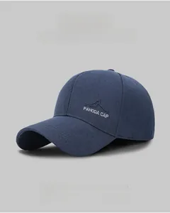 Close-up of embroidered mountain peak logo and text on navy twill baseball cap