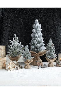 Close-up of mini flocked snow Christmas trees with rustic burlap base for holiday decor