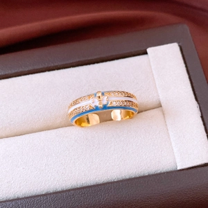 Macro view of 18k gold plated ring with blue enamel iris and pave-set zircons