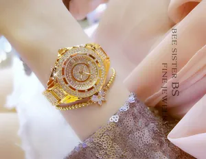 Detailed view of luxury gold watch with full rhinestones and butterfly charm bracelet