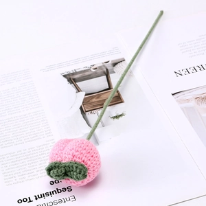 Makroaufnahme einer handgestrickten rosa Tulpe mit feiner Häkelstruktur aus Wollgarn