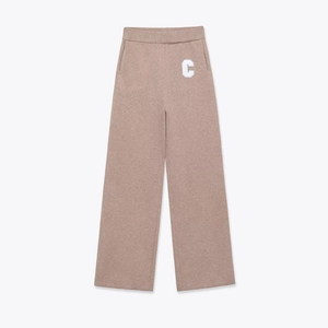Detail of high-waisted knit wide-leg pants in earthy brown with white embroidered C letter