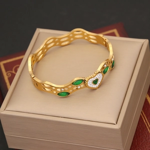 Vintage gold wave bangle with emerald heart and white zircon in a jewelry box