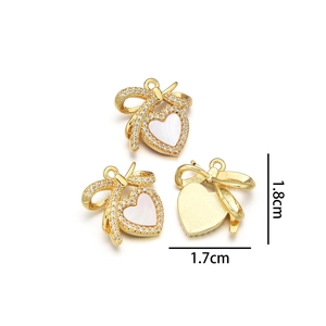 Macro view of gold heart pendants with white shell and bow detail, sized 1.8cm x 1.7cm