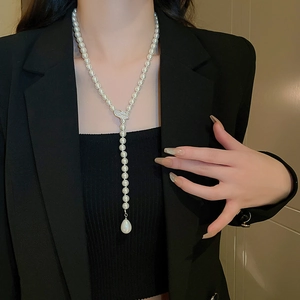 Detail of elegant Y-shaped pearl sweater necklace with leaf motif and teardrop pendant