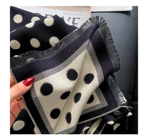 Detailed view of black and white polka dot scarf with soft fringed edges and thick texture