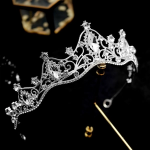 Close-up of silver bridal crown with baroque filigree and sparkling rhinestones