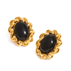 Detail of vintage braided gold earrings featuring oval black agate stone inlays