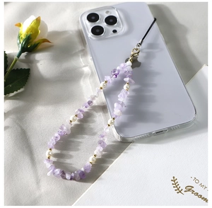 Détail de la lanière de téléphone en pierres de cristal violettes et perles blanches