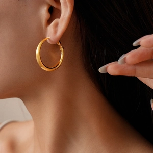Close-up of matte 18k gold plated hoop earrings with a brushed satin metal finish