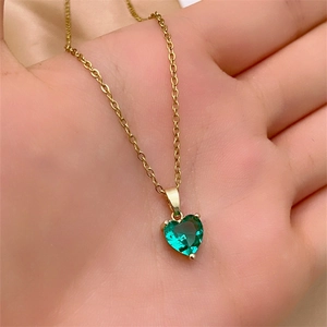 Close-up of heart-shaped green zircon pendant with gold plated stainless steel chain