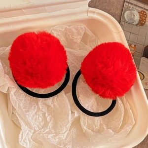 Detailed view of red faux fur pom pom hair ties with black elastic bands for kids