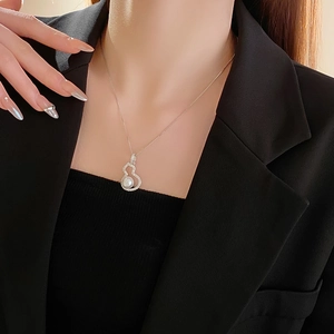 Detail of zircon gourd and pearl necklace worn on neck for an elegant jewelry look