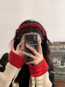 Detailed close-up of a burgundy knitted headband with a vintage twisted cable pattern