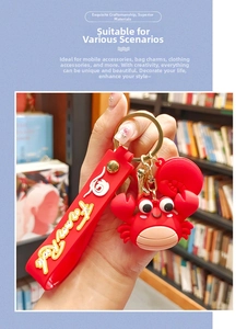 Detailed macro view of the bright red crab keychain with golden metal clasp and strap