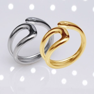 Detail of silver and gold stainless steel rings with a minimalist double wave design