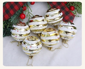 Detailed view of six gold and white striped Christmas ornaments with colorful stars