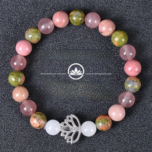 Detail of beaded gemstone bracelet with silver lotus charm and natural crystal stones