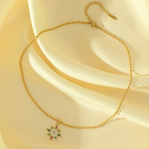 Elegant gold beaded chain necklace with multi-colored zircon star pendant on silk fabric
