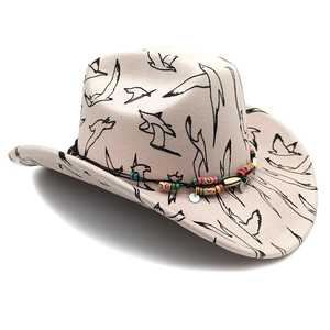 Detail of off-white cowboy hat featuring bird print, colorful beads and metal pendants
