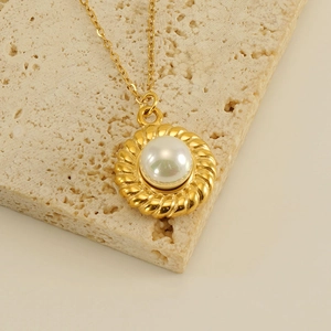 Elegant 18k gold plated sunflower pearl pendant necklace on a minimalist travertine stone