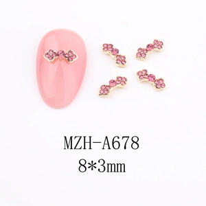 Close-up of pink rhinestone nail charms with gold metal base and 8x3mm dimensions