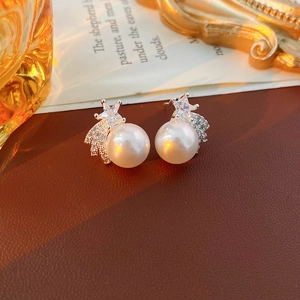 Gros plan de boucles d'oreilles perles avec étoiles en zircon sur cuir vintage