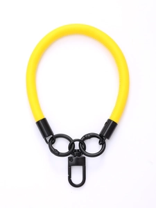 Detail of yellow leather phone wrist strap with black metal ring and clasp on white background