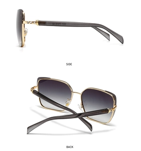 Detail of oversized metal sunglasses with rhinestone temples and gradient grey lenses