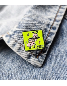 Detail of a pink ant playing guitar enamel pin with Music No.70 Ant text on denim jacket