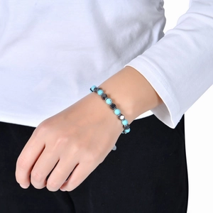 Bracelet bohème avec perles bleues et pierres grises facettées porté au poignet