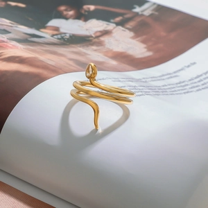 Bague serpent dorée élégante avec détail en cristal sur un magazine de mode chic
