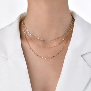Close-up of gold, silver, and rose gold minimalist thin chain necklaces worn on a model
