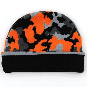 Detail view of knitted beanie with orange and grey camouflage pattern on white background