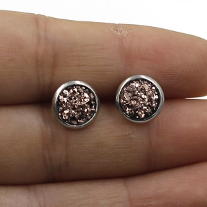 Detailed close-up of 8mm stainless steel stud earrings with sparkling brown crystals