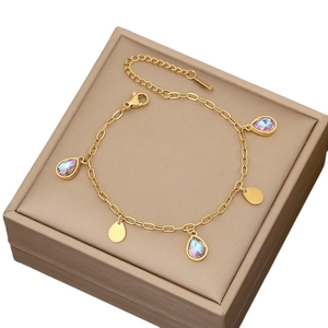 Elegant gold butterfly bracelet with purple drop pendants on a jewelry gift box