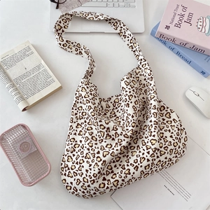 Retro leopard heart canvas tote bag displayed on a desk with daily essentials