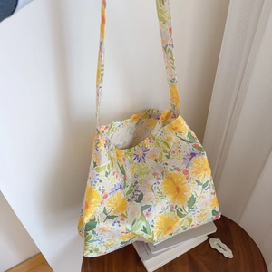 Detail of the yellow floral cotton tote bag showing daisy patterns and fabric texture