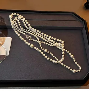 Close-up of elegant double layered pearl necklace with crystal inlaid number 5 pendant
