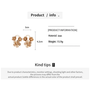 Détail de boucles d'oreilles fleurs ajourées dorées en fer avec dimensions 3cm sur 4,2cm