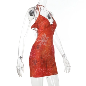 Détail d'une mini-robe dos nu sexy avec imprimé floral de roses orange et dos ouvert