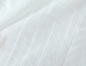 Close-up of white jacquard fabric with striped texture and breathable knit patterns